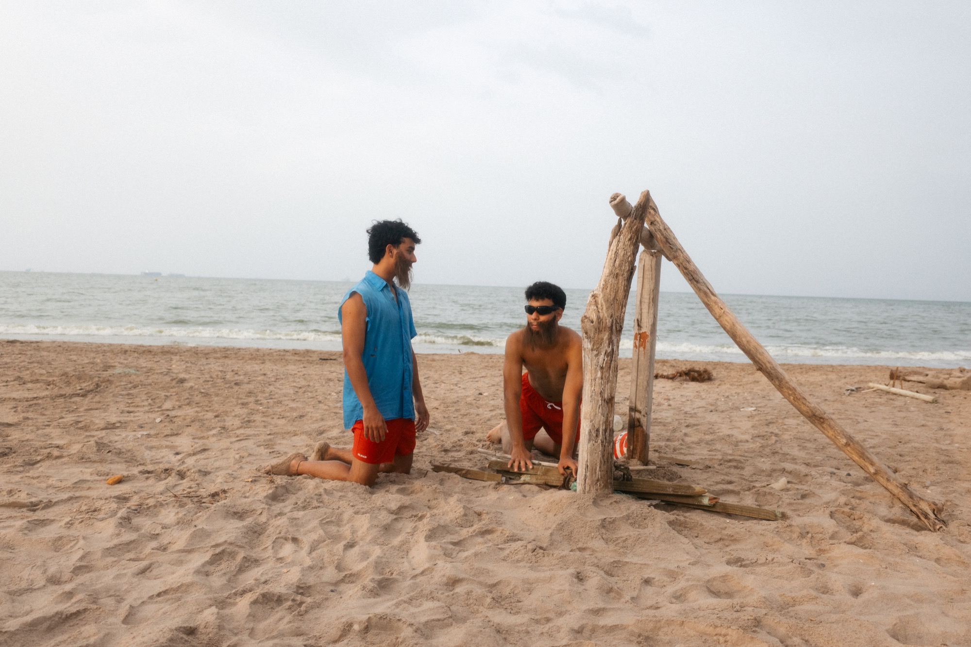 Los protagonistas junto a su refugio de madera en la playa